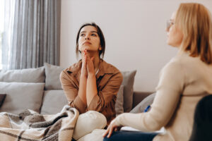 distressed woman sits on a couch and asks therapist what is dmt