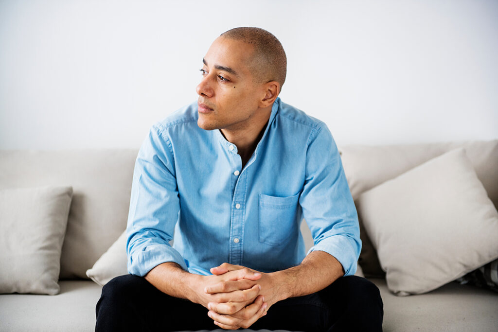 Man sits on couch and considers xanax side effects